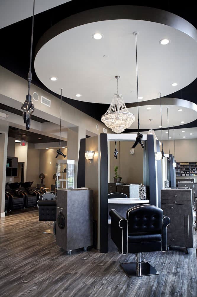 Elegant salon interior with chandelier lighting and suspended Freestylist weightless dryers.