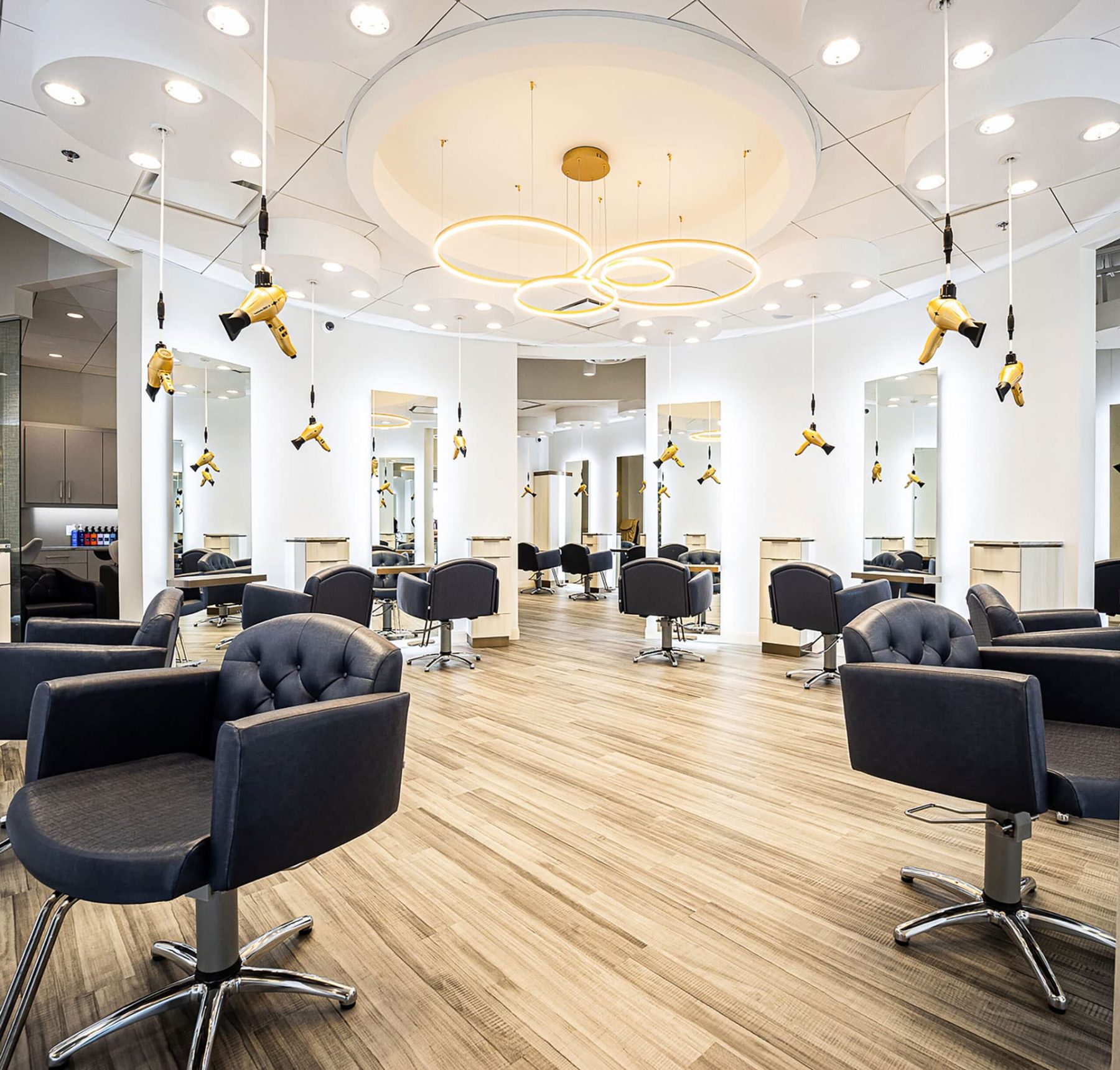 Luxury salon interior featuring gold Freestylist weightless blow dryers suspended from the ceiling.