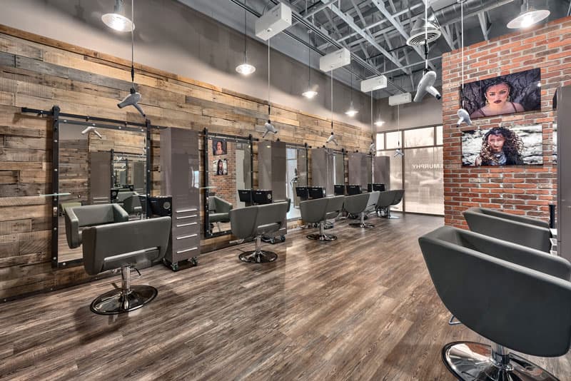Industrial-chic salon interior with Freestylist dryers suspended over modern styling stations.