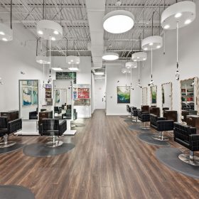 Modern salon interior with black chairs, mirrors, and Freestyle Systems hair dryers at Zinke Hair Studio Jacksonville.