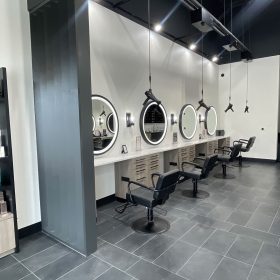 Modern salon styling stations with suspended Freestylist weightless hair dryers at Pure Posh at Shavano in San Antonio Texas
